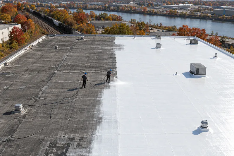 Low-slope roof with white silicone coating applied over half the field